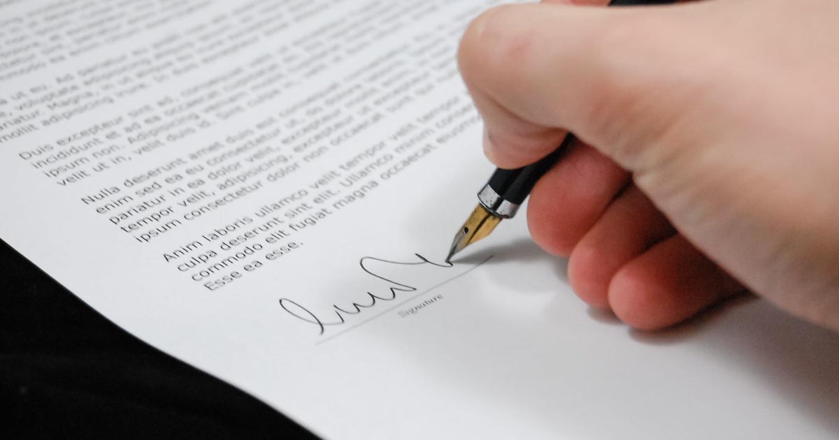 person signing paper